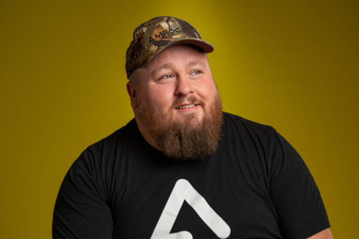 Photo of Ricky Crandell making an impact in front of a yellow background.