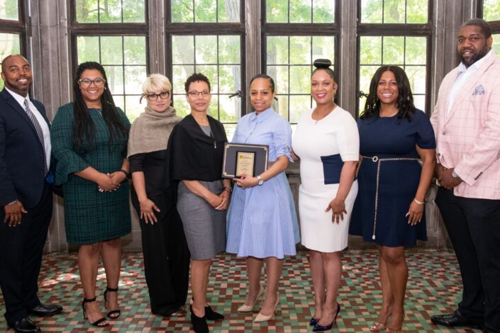 Photo of eight individuals posing for the camera at the Motor City Contractor Fund awards