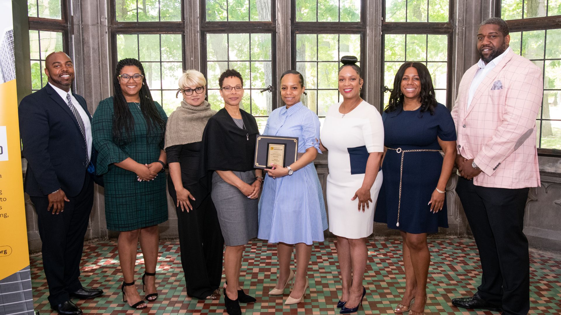 Photo of eight individuals posing for the camera at the Motor City Contractor Fund awards